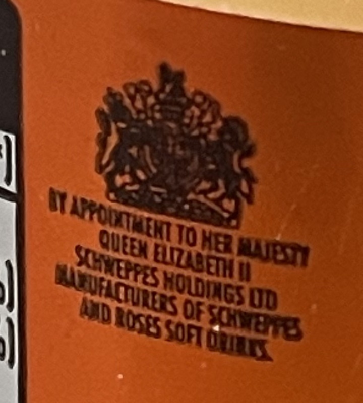 Royal arms above wording By Appointment to Her Majesty Queen Elizabeth II on an orange Schweppes label