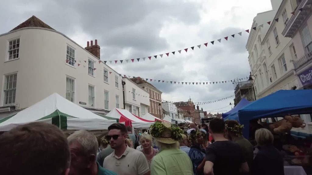  Crowds between stalls on a bunting-lined street at Faversham Hop Festival 