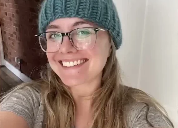Alanna wearing a blue-green knitted hat with a pom-pom.