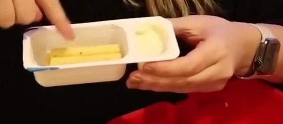 Open snack tray with breadsticks on one side and pale cheese dip on the other