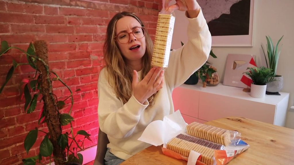 Alanna holds a sleeve of custard creams above the open four-variety biscuit assortment