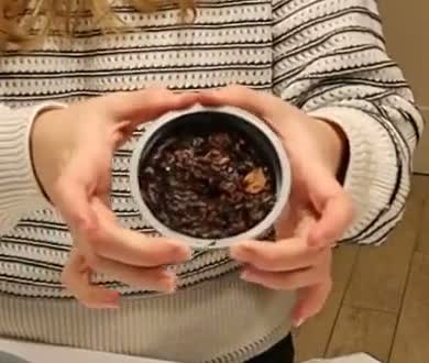 The dark, fruit-filled single-serving pudding still in its basin, held in Alanna's hands.