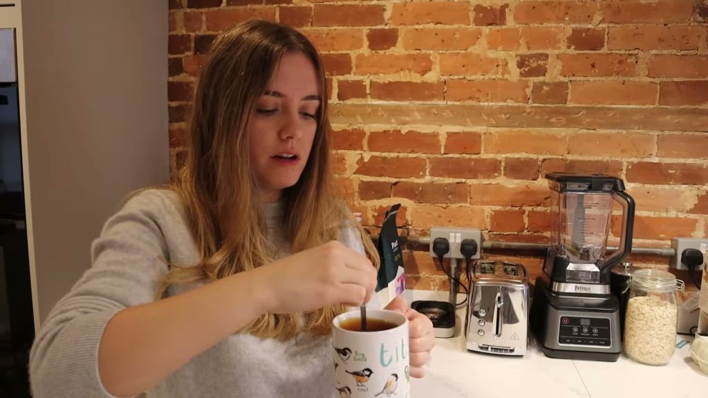 Alanna stirring dark Bovril into hot water in a mug.