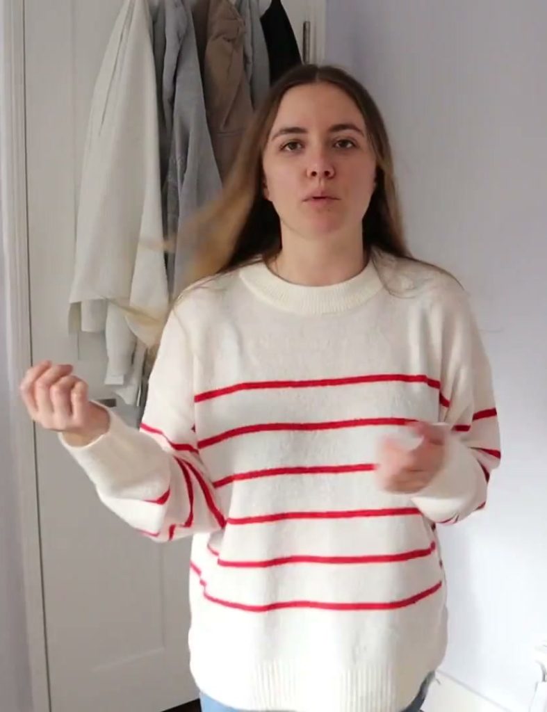 Alanna wearing the cream jumper with red stripes during the try-on