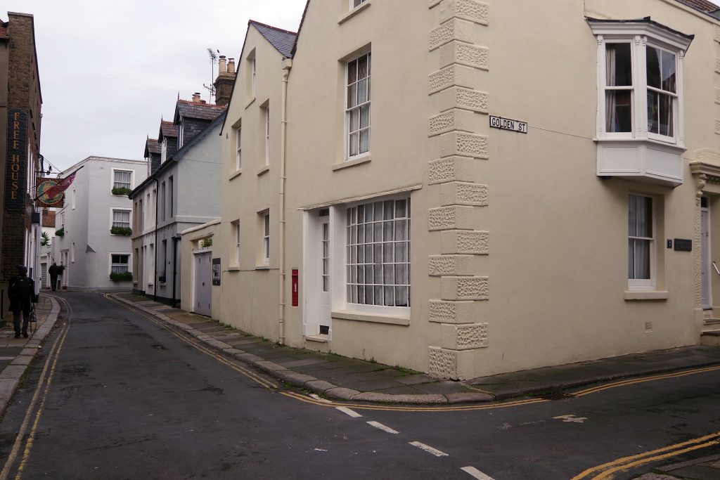 Narrow street lined with adjoining cream and white houses in Deal