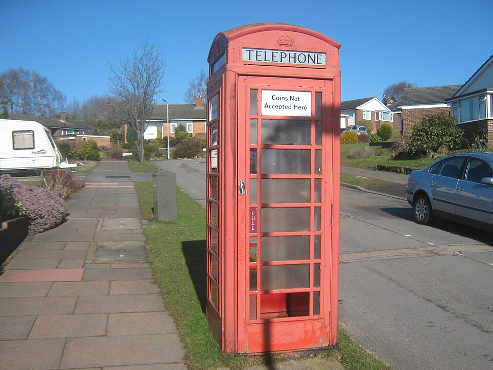 Red K6 telephone box on Rydal Drive in Tunbridge Wells, with frosted panes and weathered paint.