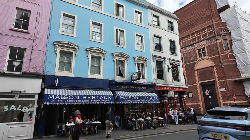 Maison Bertaux's blue frontage and striped awnings, with tables on the pavement.